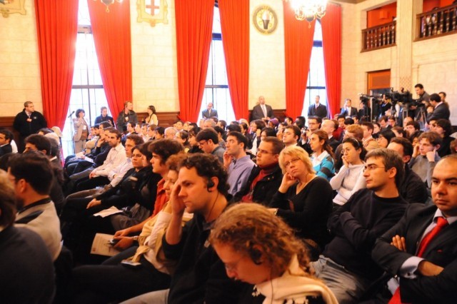 Audience members listen as the Prime Minister as he delivers a keynote address in the crowded Italian Academy Teatro. 