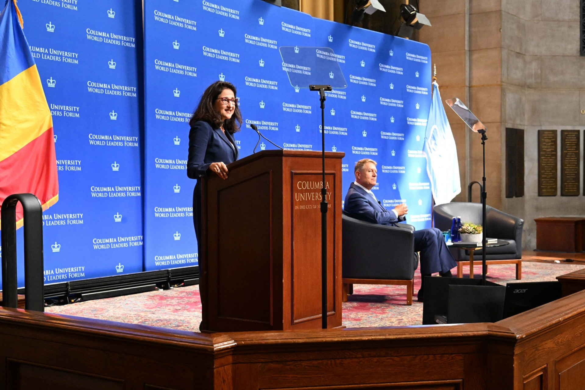 Columbia University President Minouche Shafik (left) speaking at the podium while President Klaus Werner Iohannis of Romania listens to her remarks during the World Leaders Forum