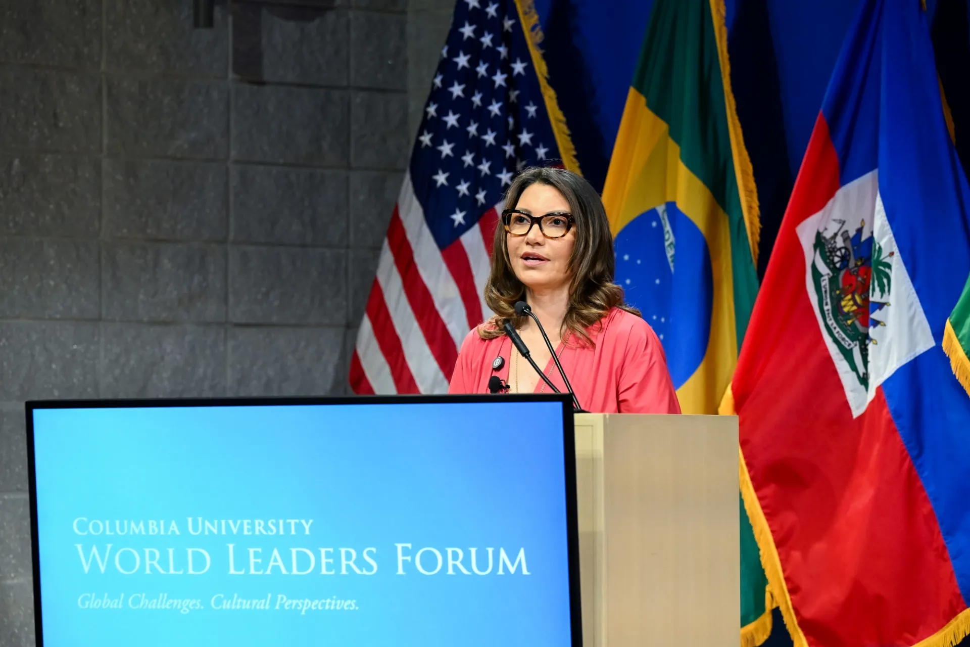 First Lady of Brazil speaking at the podium.