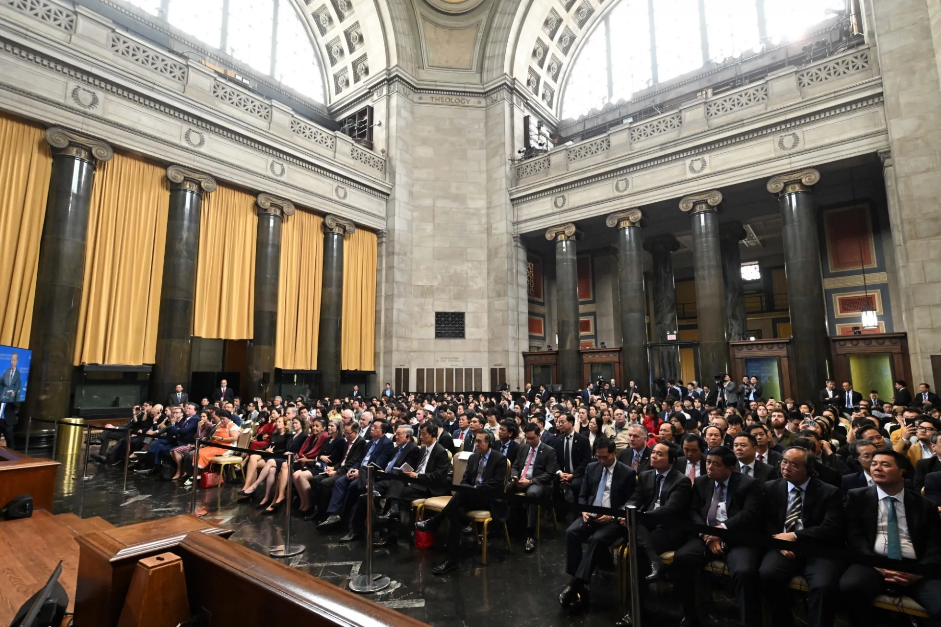 An audience including Columbia University students, scholars, and faculty listening to the discussion.